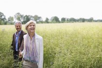 Couple walking in field of tall grass — Stock Photo