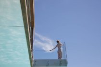 Donna con le braccia tese sul balcone moderno — Foto stock