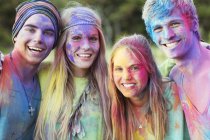 Close up portrait of friends covered in chalk dye at music festival — Stock Photo