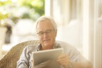 Homem sênior usando tablet digital no pátio — Fotografia de Stock