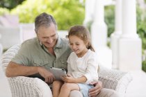 Літній чоловік і онука використовують планшетний комп'ютер — стокове фото