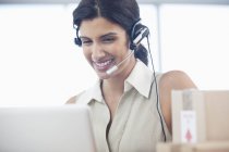Businesswoman wearing headset at desk at modern office — Stock Photo