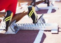 Runner's feet in starting blocks on track — Stock Photo