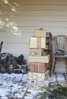 Stack of Christmas gifts on snowy patio — Stock Photo