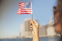 Mujer con uñas novedosas ondeando bandera americana - foto de stock