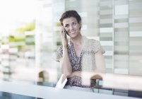 Donna d'affari che parla al cellulare in ufficio moderno — Foto stock