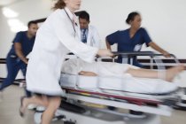 Personale ospedaliero correre paziente in sala operatoria — Foto stock