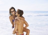 Glückliches kaukasisches Paar, das sich am Strand umarmt — Stockfoto