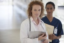 Врач и медсестра стоят в коридоре современной больницы — стоковое фото