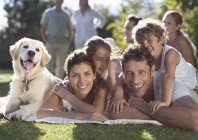 Happy family relaxing in backyard with dog — Stock Photo