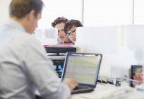Empresários bisbilhotando colega no escritório moderno — Fotografia de Stock