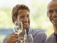 Uomini che bevono vino insieme al chiuso — Foto stock