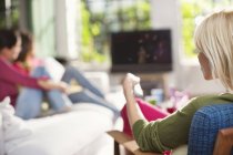 Woman switching channel on television — Stock Photo