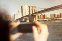 Hands taking picture of urban bridge and cityscape — Stock Photo