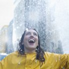 Enthusiastic caucasian woman standing in rain — Stock Photo