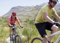 Dos ciclistas de montaña caucásicos en el camino de tierra - foto de stock