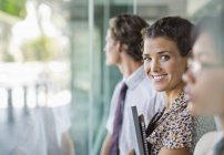 Бізнес-леді посміхається у сучасному офісному вікні — стокове фото