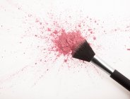 Pincel de maquiagem e salpicos de pó de blush rosa — Fotografia de Stock