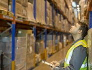 Worker checking boxes in warehouse — Stock Photo