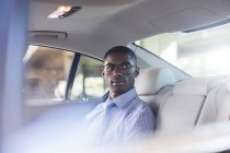 Businessman sitting in car back seat — Stock Photo