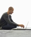Человек, использующий планшетный компьютер в гостиной — стоковое фото