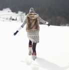 Женщина, идущая по снежному полю — стоковое фото