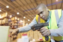 Worker scanning boxes in warehouse — Stock Photo
