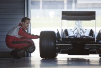 Механік, що працює на гоночному автомобілі в гаражі — стокове фото
