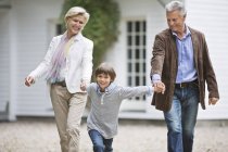 Couple walking with grandson outdoors — Stock Photo