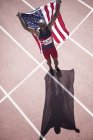 Atleta di atletica leggera con bandiera americana in pista — Foto stock