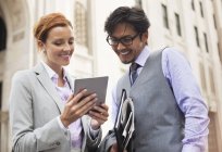 Business people using tablet computer on city street — Stock Photo