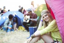 Портрет улыбающейся женщины в палатке на музыкальном фестивале — стоковое фото