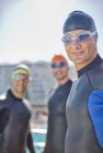 Confident and strong triathletes wearing wetsuits outdoors — Stock Photo