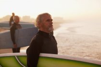 I surfisti più anziani che trasportano tavole sulla spiaggia — Foto stock