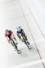Track cyclists racing in velodrome — Stock Photo
