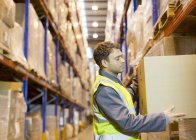 Worker stacking boxes in warehouse — Stock Photo