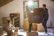 Friends moving furniture in new home — Stock Photo