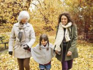 Tres generaciones de mujeres caminando en el parque - foto de stock