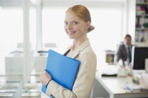 Portrait of confident businesswoman holding folder — Stock Photo