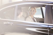 Бізнес-леді розмовляють на задньому сидінні автомобіля — стокове фото