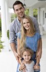 Happy family smiling together on porch — Stock Photo