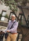 Mann schiebt Fahrrad auf Stadtstraße — Stockfoto