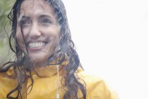 Портрет дорослої латинської усміхненої жінки під дощем — стокове фото