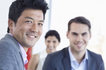Empresários sorrindo juntos no escritório moderno — Fotografia de Stock