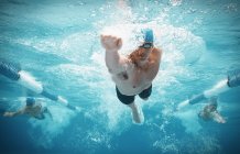 Nadadores corriendo en el agua de la piscina - foto de stock