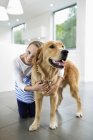 Girl hugging dog at modern home — Stock Photo