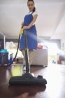 Abile donna caucasica aspirapolvere pavimento del soggiorno — Foto stock