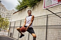 Uomo che gioca a basket sul campo — Foto stock