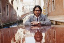 Porträt eines seriösen Geschäftsmannes auf einem Boot in einem Kanal in Venedig — Stockfoto