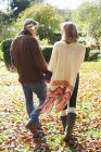 Rear view of couple holding hands outdoors — Stock Photo